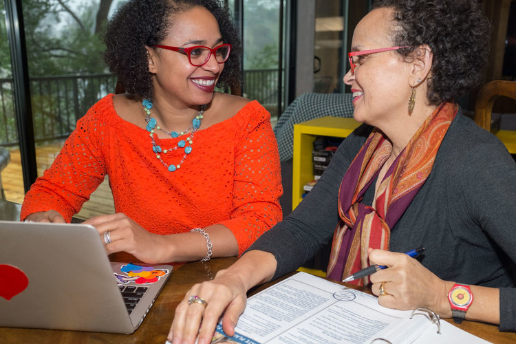 Portia reviewing documents with a client at a table